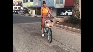Jade Chynoweth riding a bicicle in bikini bottoms