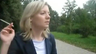 Blonde beauty smoking a cigarette outdoors